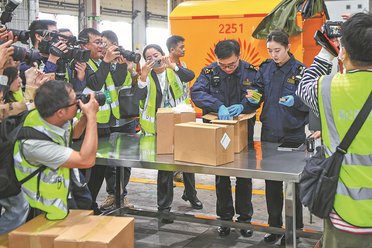 Customs officers conduct inspections on the first batch of goods to enjoy the policy of duty-free processing value-added tax at Haikou Meilan International Airport in Haikou on Dec 18. SU BIKUN/FOR CHINA DAILY